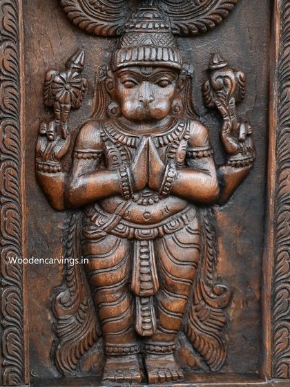 A close-up of Lord Hanuman from the Kavadi, showing the detailed carving of his face and hands.