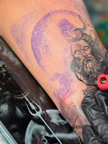The process begins with a perfect stencil. Here you can see the detailed outline for a Mahadev portrait, ensuring every line is precise before the needle touches the skin.
