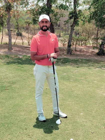 Posing with a driver on the tee box. Having confidence in your long game is a game changer, and it all begins with mastering the fundamentals of the driver swing.