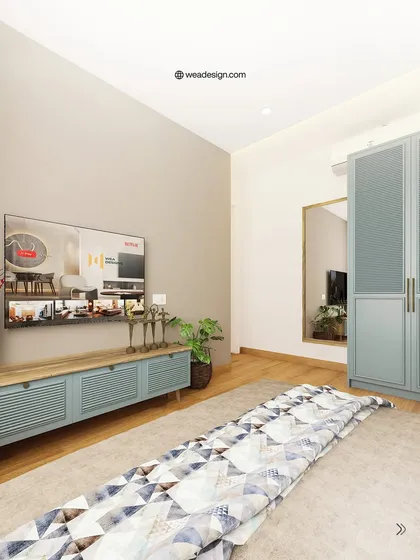 This bedroom design features a calming color palette with a pastel blue TV console and matching wardrobe, creating a serene and cohesive space.