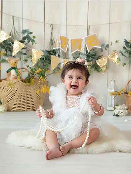Capturing that big, gummy smile is what milestone sessions are for. This little one is celebrating her ability to sit up, and her happy expression shows how much fun we have in the studio.