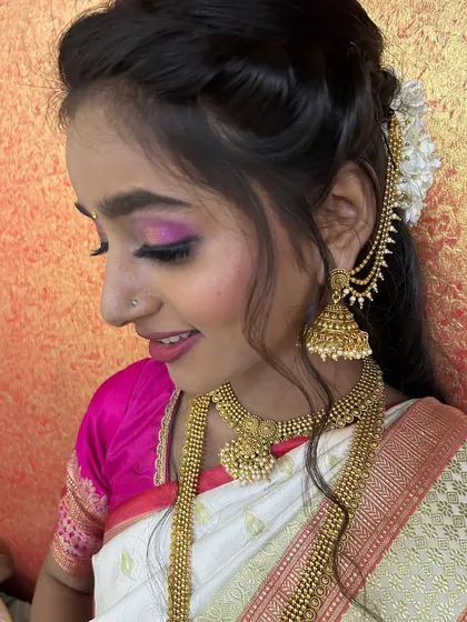 A side profile showing the beautiful details of the hairstyle and the 'kaan vel' ear accessory, which adds a traditional touch to the look.
