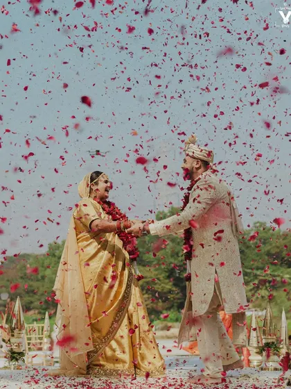 A moment of pure celebration as the couple is showered in petals. This frame captures the peak of happiness, a memory of shared joy that they will look back on and smile at for years to come.