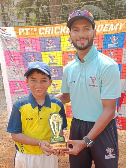 A smiling U-10 player receives his Man of the Match trophy from a coach. We make sure every great performance is acknowledged.