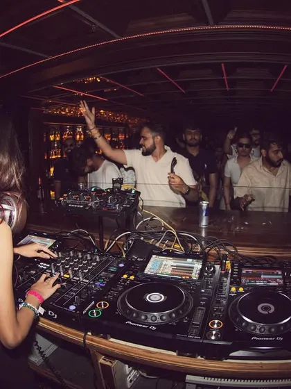 A fisheye lens captures the energy of the room, showing me at the decks and the crowd with their hands up.