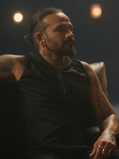 A tough-looking biker character from the Tata Play ad, styled in all-black athletic wear with tattoos and edgy accessories.