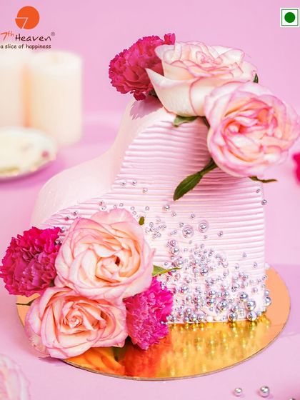 Edible love, baked to perfection. This stunning heart-shaped cake, adorned with fresh roses and delicate silver pearls, is the ultimate romantic centerpiece.