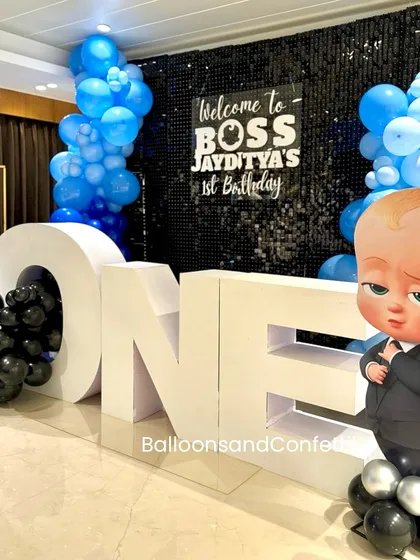 A wider view of the Boss Baby setup, showing the 'ONE' table filled with black balloons and the custom backdrop welcoming guests to the party.