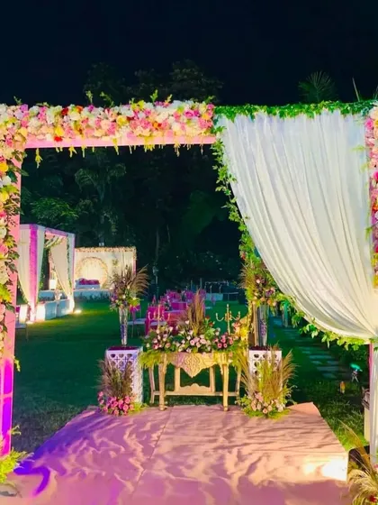 A lovely floral entrance arch for an outdoor wedding. The pink and white flowers combined with the white drapes create a fresh and romantic garden party feel.