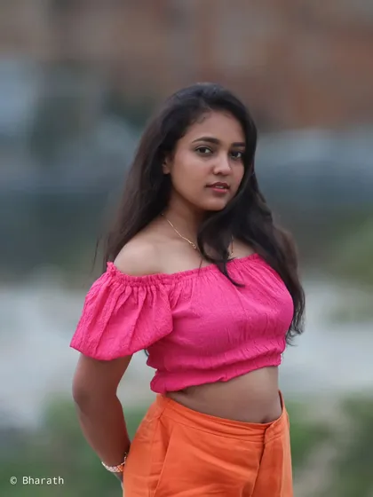 A close-up portrait focusing on the model's expression and the bright colors of her top.