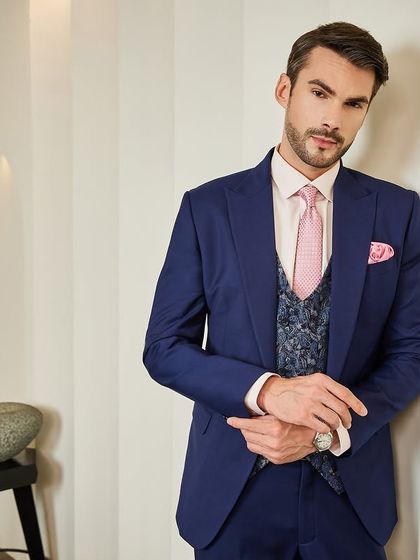 A closer look at the navy three-piece suit. The texture of the jacquard waistcoat contrasts beautifully with the smooth wool of the jacket, showcasing a keen eye for detail.