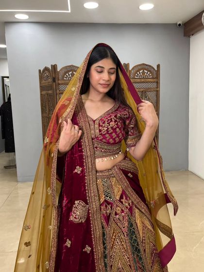 The model adjusts the dupatta, giving a great view of the intricate work on the sleeves and the elegant fall of the fabric.