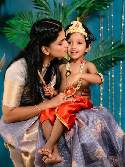 A mother gives her 'Little Krishna' a sweet kiss on the cheek. These themed sessions are filled with love, tradition, and adorable moments.