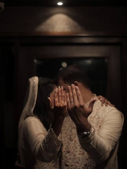 A playful and intimate "reveal" of the rings. This candid style of ring photography captures the couple's personality and the happy reality of being newly engaged.