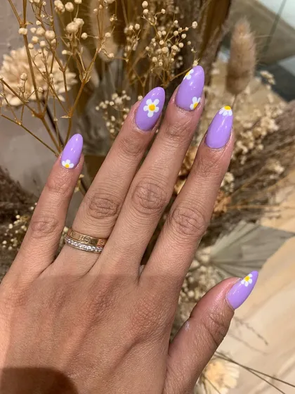 A simple and sweet summer nail art design. This look features a pastel lavender base with cute, hand-painted daisies.