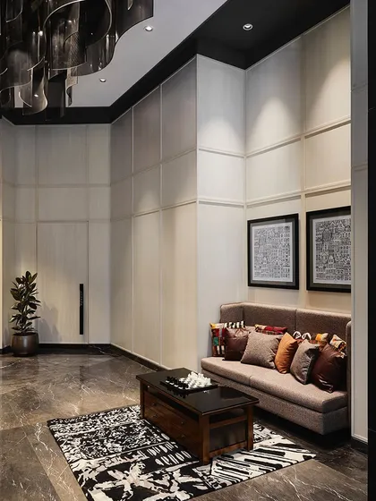Another view of the lobby seating area, showcasing the rich textures of the marble floor, area rug, and the dramatic overhead lighting fixture.