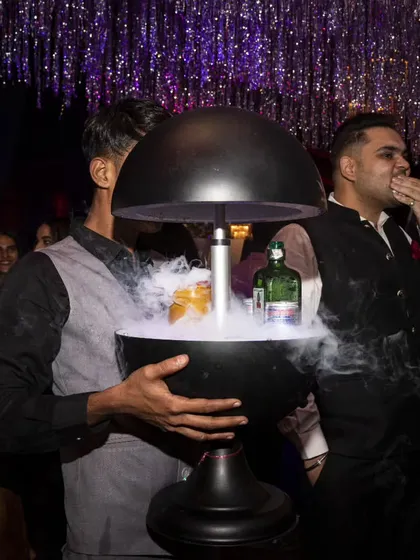 A guest watches as a smoky cocktail is unveiled. We focus on creating these small moments of theater throughout your event.