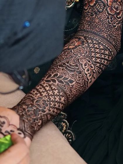 A close-up of me adding the groom's name, "Lava", to the bride's mehendi.