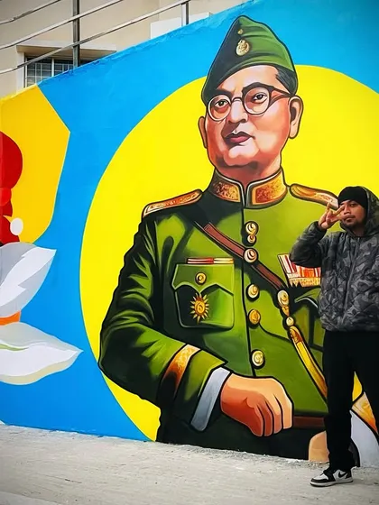 Here I am with my mural of freedom fighter Subhash Chandra Bose. This portrait is part of the 100-foot wall at St. Claret College, painted with bold colors to honor his legacy.