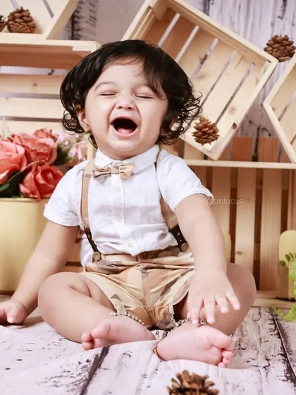 A big, joyful laugh from a little boy in our wooden-themed set. We love capturing these spontaneous moments of happiness.