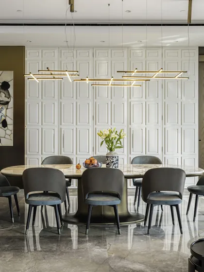 In this modern fusion home, the dining space is where functionality and aesthetics merge. A majestic Caracutta Oro marble table comfortably hosts ten, while the playful asymmetry of the flooring contrasts beautifully with the pristine minimalism of the white ceiling.