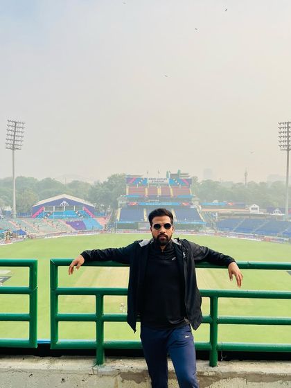 Taking it all in. Leaning against the railing, overlooking the vast expanse of the cricket ground.