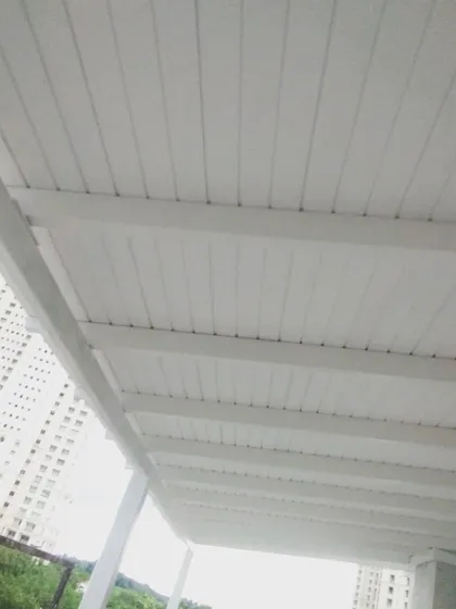 A view from below of the clean, white slatted ceiling of the European-style pergola. It gives the space a bright and airy feel while providing full coverage from the sun.