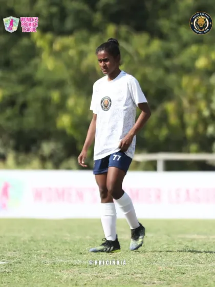 A player stands ready on the pitch, focused and waiting for the play to develop during a Women's Premier League game.