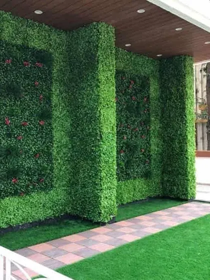 This terrace design uses artificial green walls to create an elegant, enclosed feel. The inset panels with floral accents add a touch of detail and sophistication to the outdoor space.
