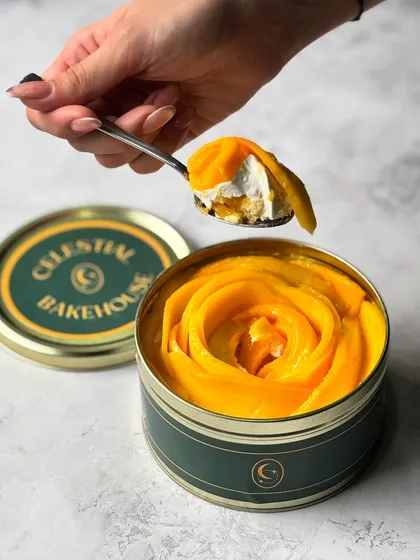 A perfect spoonful of our Mango Tres Leches. You can see the layers of soaked cake, luscious cream, and fresh mango in this single bite.