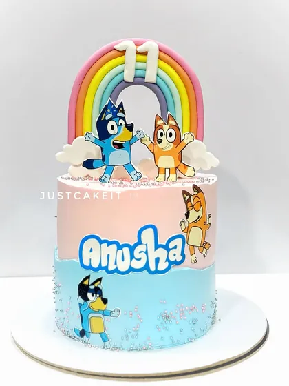 A Bluey-themed cake with edible characters and a pastel rainbow. This is a great example of a modern, popular kids' show theme.