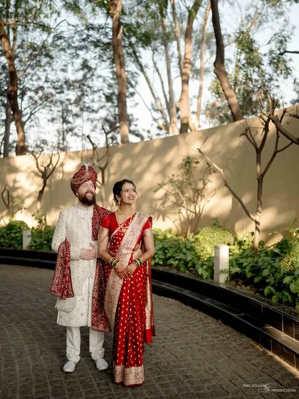 A classic wedding portrait set against a natural backdrop. The couple's relaxed posture and happy expressions make for a timeless and beautiful memory.