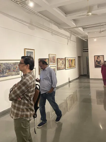 Visitors at the Vidya Bhushan retrospective, observing a long wall of his paintings. The curation aimed to show the evolution of his style over several decades.