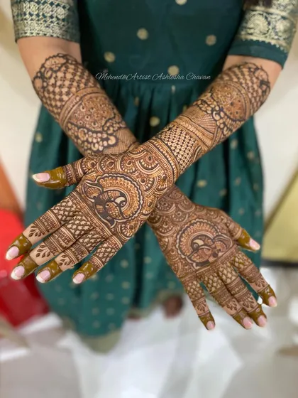 The back of a bridal mehendi design. The intricate patterns with peacock motifs create a stunning look from every angle.