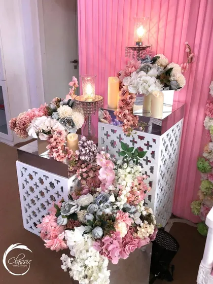 I used these white lattice stands to display cascading arrangements of pastel flowers, adding layers and dimension to the overall Mehendi decor.