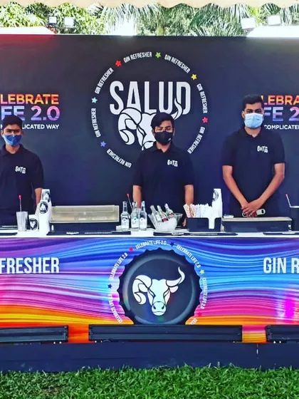 A clean and vibrant bar setup for a Salud Gin Refresher event at a flea market. Our team stands ready to serve, showcasing the product in a colorful, branded environment designed to attract attention.