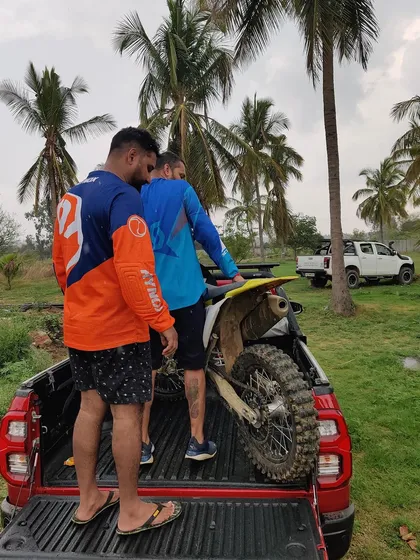 Teamwork extends beyond the track. Here, our members help load a dirt bike onto a truck after a long day of riding. Many hands make light work.