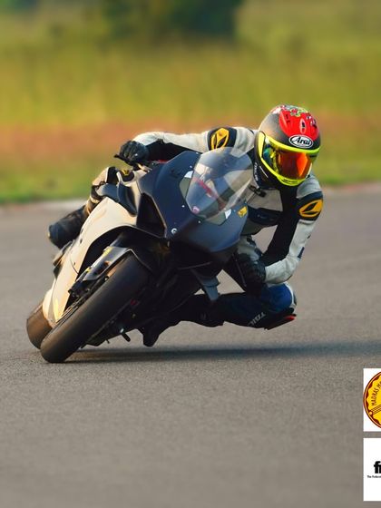 A rider demonstrating excellent form and body position, hanging off the bike to maintain stability and speed through the turn.