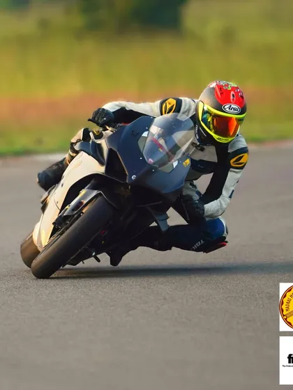 A rider demonstrating excellent form and body position, hanging off the bike to maintain stability and speed through the turn.