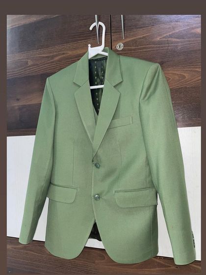 This light green blazer, seen here on a hanger, shows the quality of my stitching. The lapels are perfectly pressed and the pockets are flawlessly integrated.