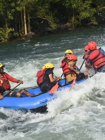 A side view of a raft being expertly maneuvered through white-water by our guide, showcasing the technical skill involved in the sport.