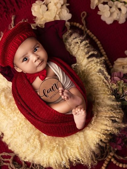 Marking the four-month milestone with a classic portrait. The rich red and cream tones create a warm and timeless feel for this adorable sitter session photo.