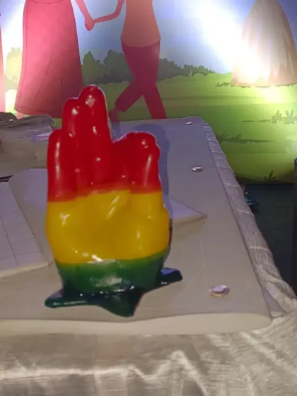 A close-up of a colorful, multi-layered wax hand sculpture. This shows the beautiful and detailed keepsakes that guests can create and take home from your event.