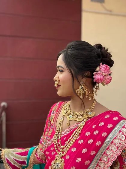 This messy bun is adorned with a fresh lotus flower and moon-shaped accessories, creating a unique and artistic look for a traditional Maharashtrian wedding.