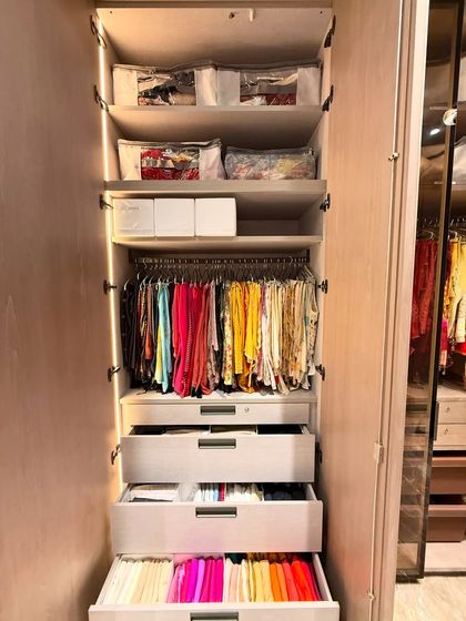 Another example of a beautifully organized wardrobe, combining hanging space with drawers and top-shelf storage.