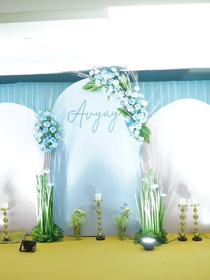 A serene and elegant backdrop for Avyay's celebration. We used clean, arched panels in white and a soft blue curtain, accented with delicate blue and white floral arrangements for a dreamy look.