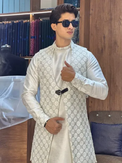Another look at the elegant white-on-white layered kurta set. The geometric pattern on the open jacket adds texture and depth, making it suitable for any grand occasion.