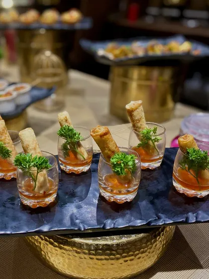 Presentation is key for passed appetizers. Here, I serve crispy spring rolls in individual glasses with a sweet chili dipping sauce at the bottom, an elegant and mess-free way for guests to enjoy a classic starter.