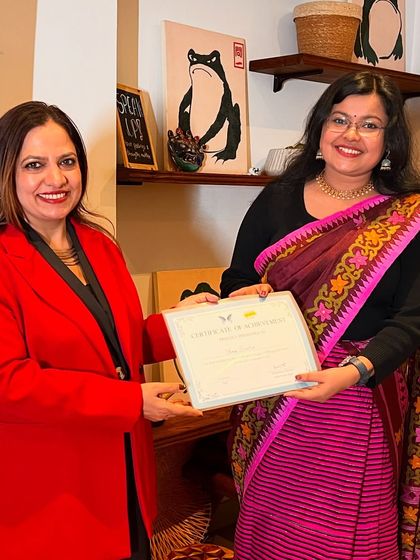 A winner dressed in traditional attire receives her certificate, representing the beautiful diversity of our participants.