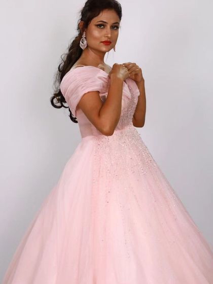 A beautiful pose in the pink off-shoulder ball gown, showcasing its flattering silhouette and romantic charm.